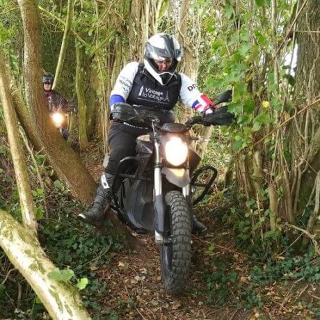 a photo of a person on a motorbike in a wooded area