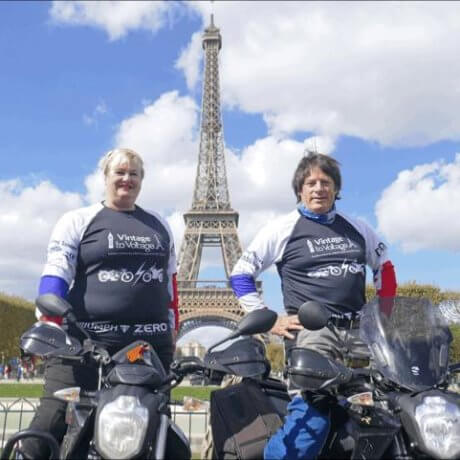 a photo of two people on motorbikes in front of the Eiffel Tower